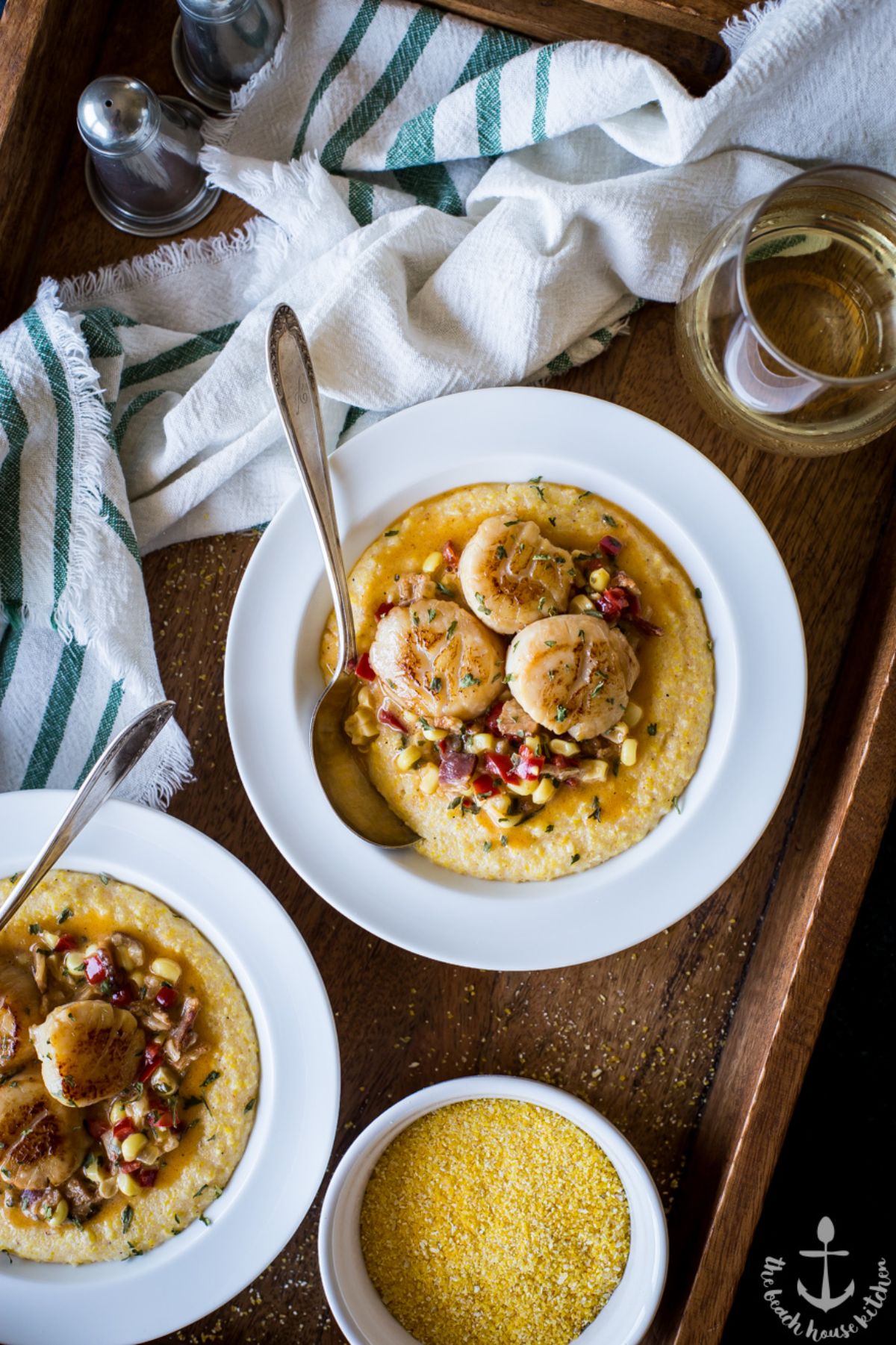 Creamy Scallops and Grits on white plates with spoons.