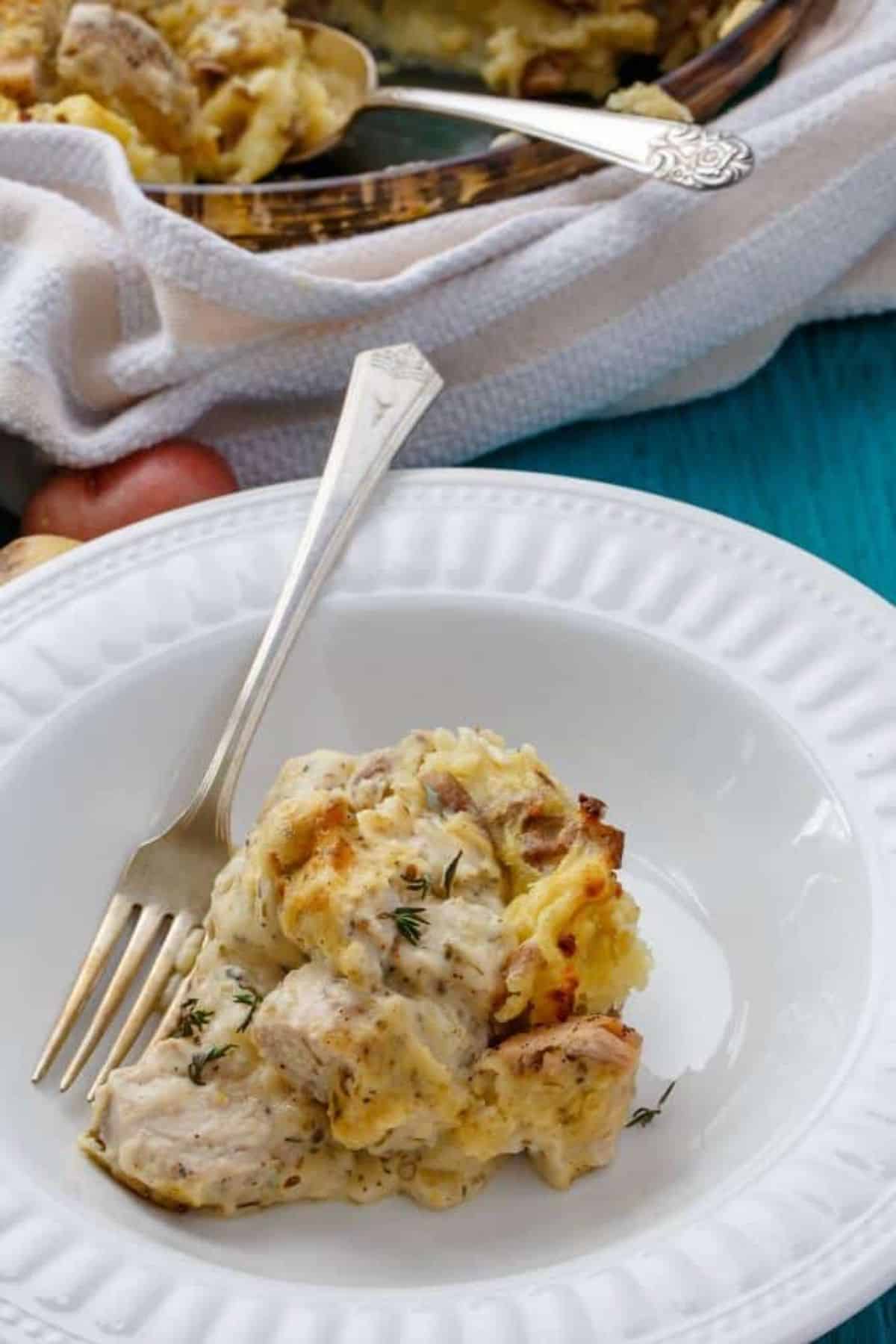 Juicy Mashed Potato Chicken on a white plate with a fork.