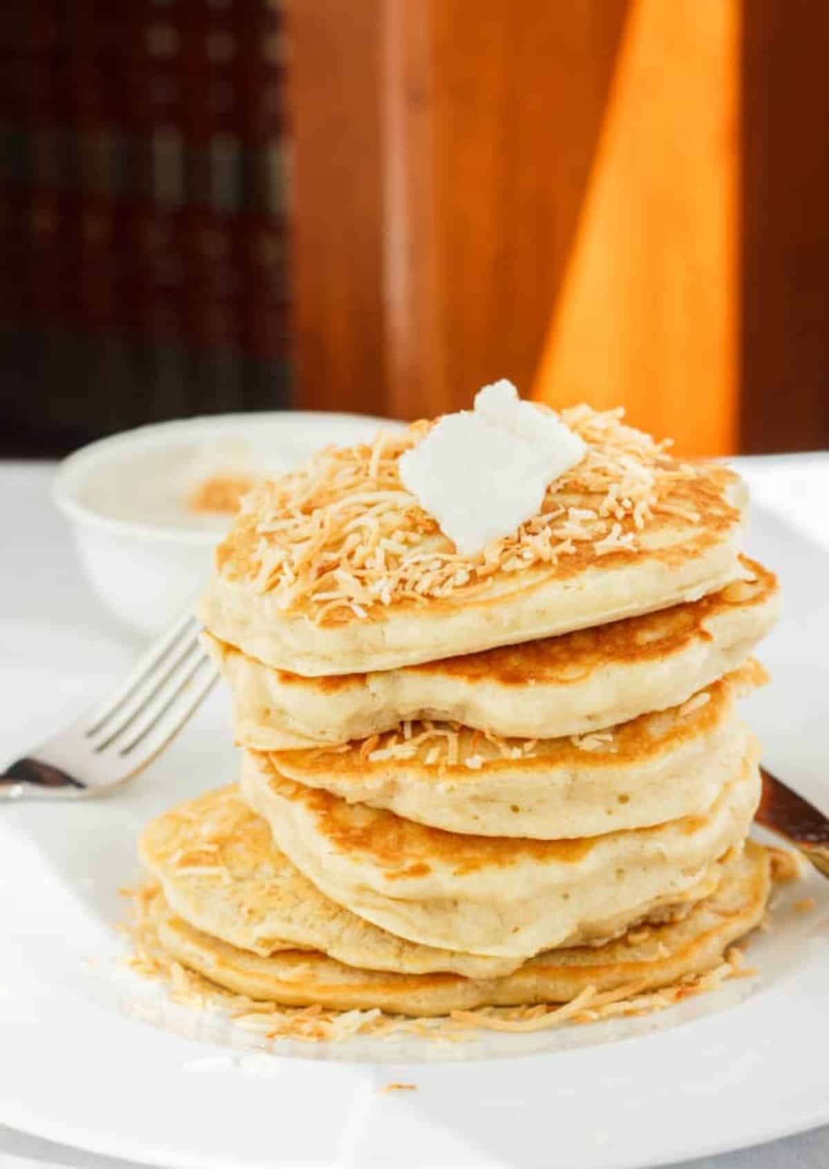 A pile of Roasted Coconut Pancakes on a white plate.