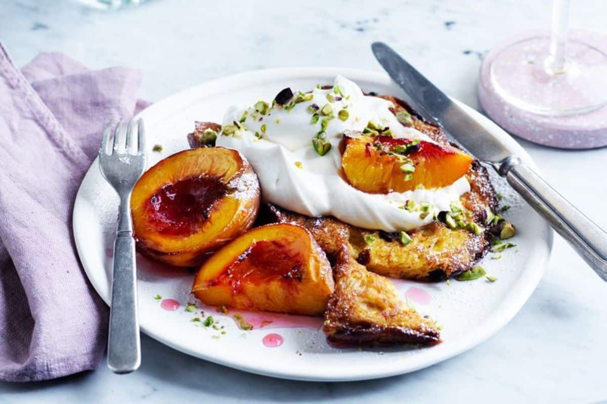 Mouth-watering Panettone French Toast with cutlery on a white plate.