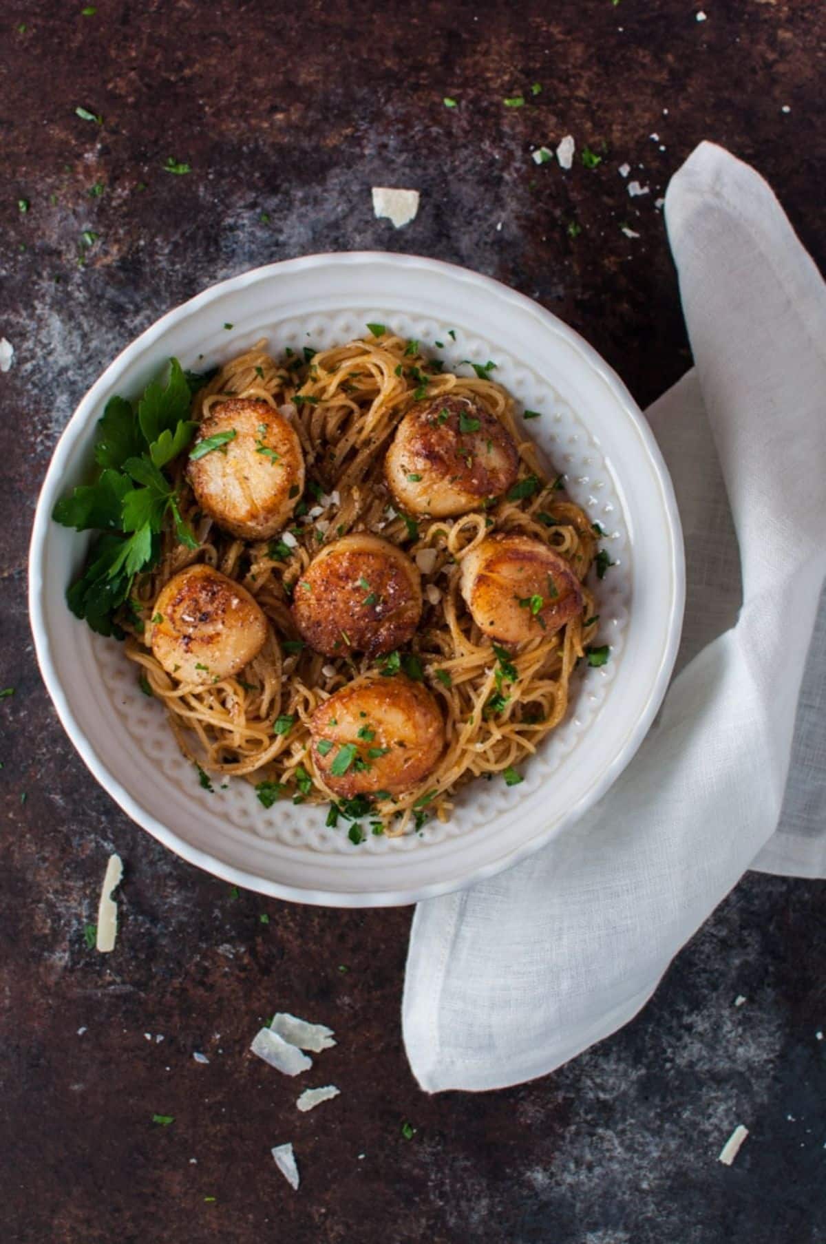 Scrumptious Chipotle Lemon Tarragon Scallops with Angel Hair Pasta in a white bowl.