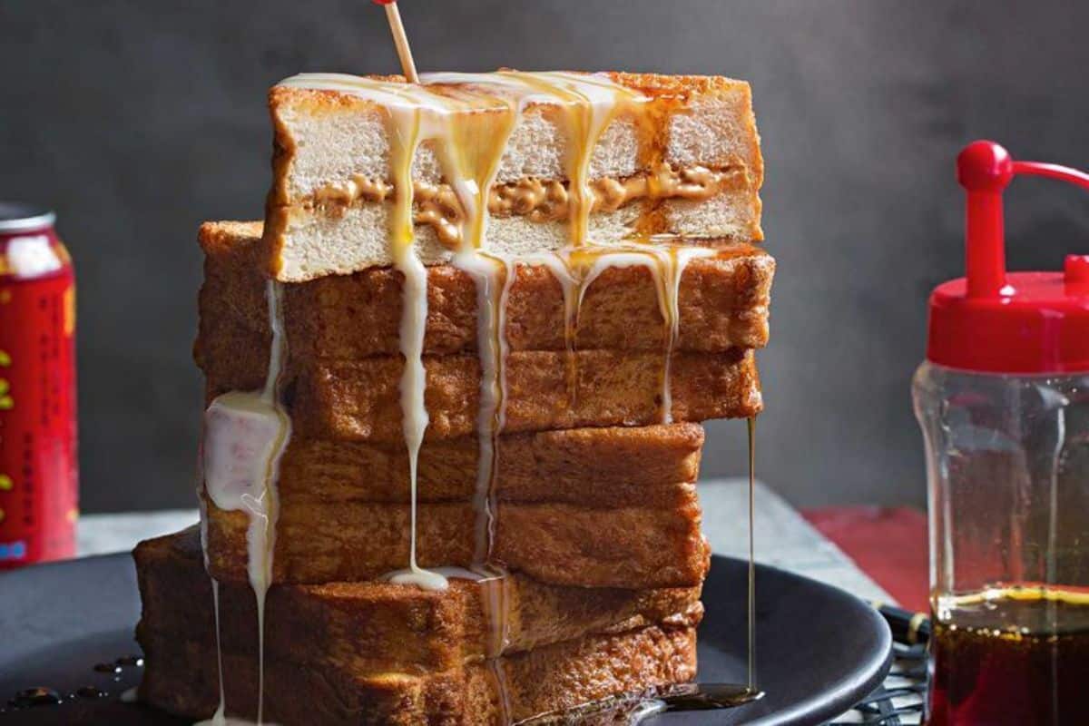 A pile of Hong Kong-style French Toast on a black plate.