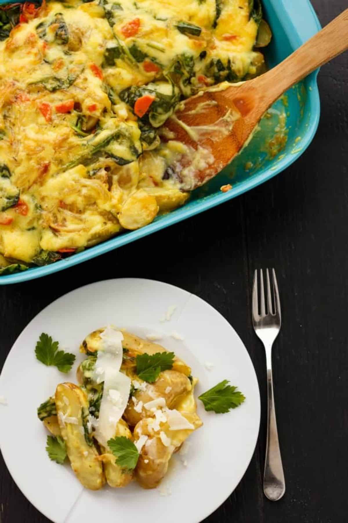 Creamy Breakfast Potato Casserole with Hollandaise Sauce in a blue casserole and on a white plate.