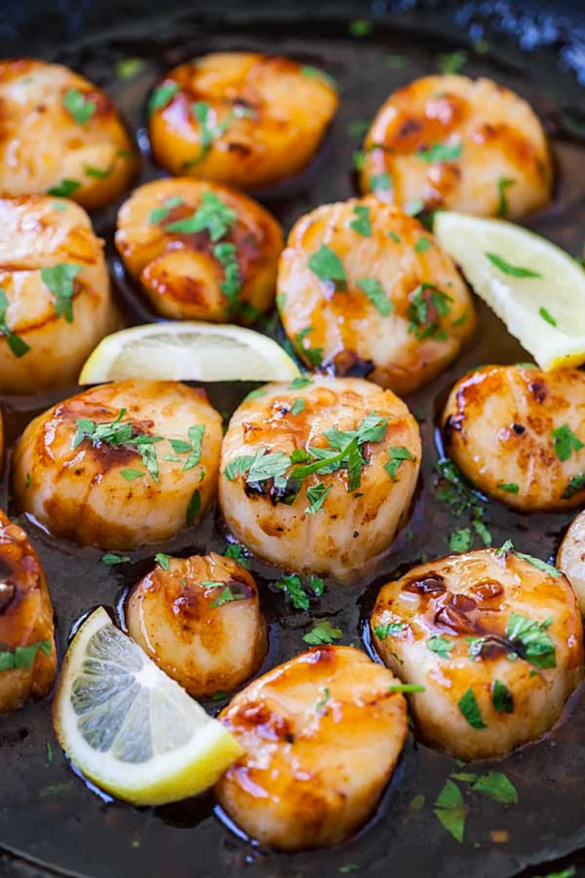 Delicious Honey Sriracha Scallops on a black pan.