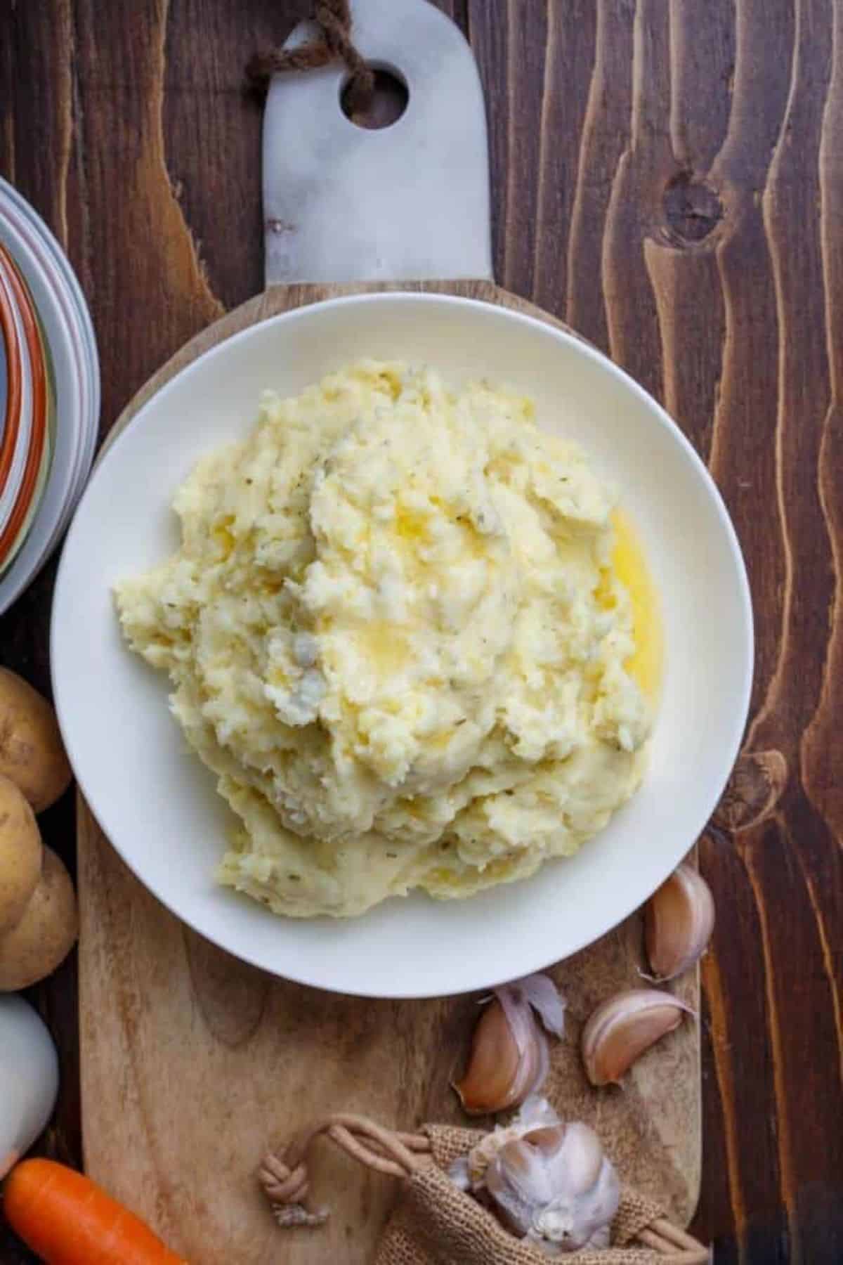 Healthy Herb and Garlic Cream Cheese Mashed Potatoes on a white plate.
