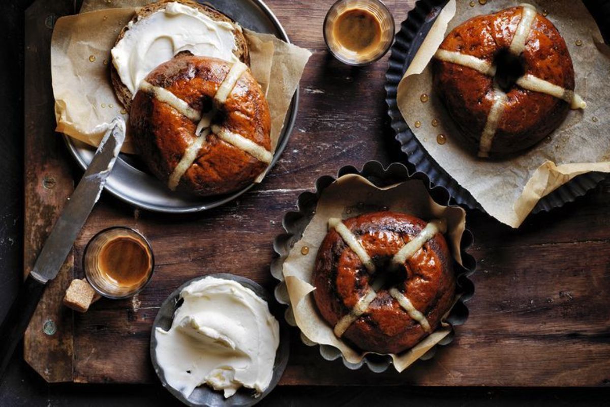 Scrumptious Cinnamon and Coffee Hot Cross Bagels on a wooden tray.