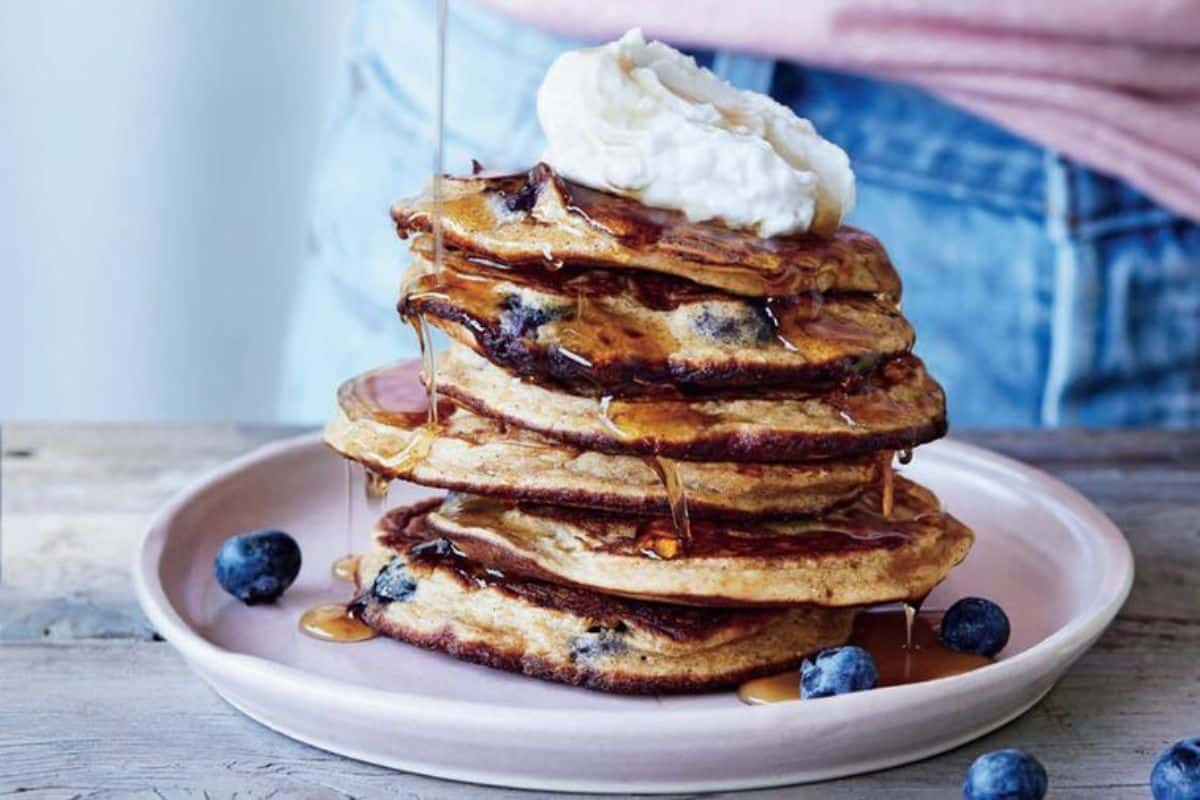 A pile of Buckwheat Blueberry Pancakes on a pink tray.