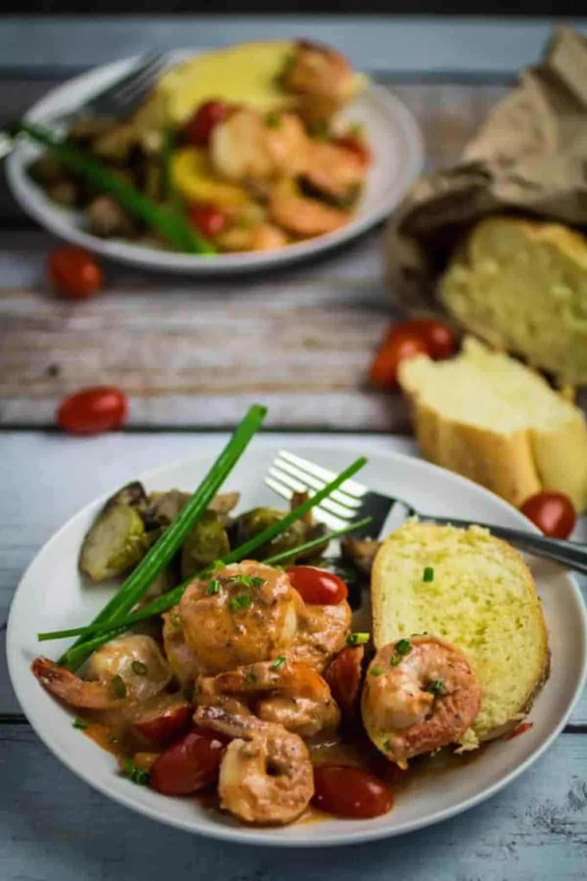 Delicious Shrimp and Scallops in Creamy Marinara Sauce on a white plate with a fork.