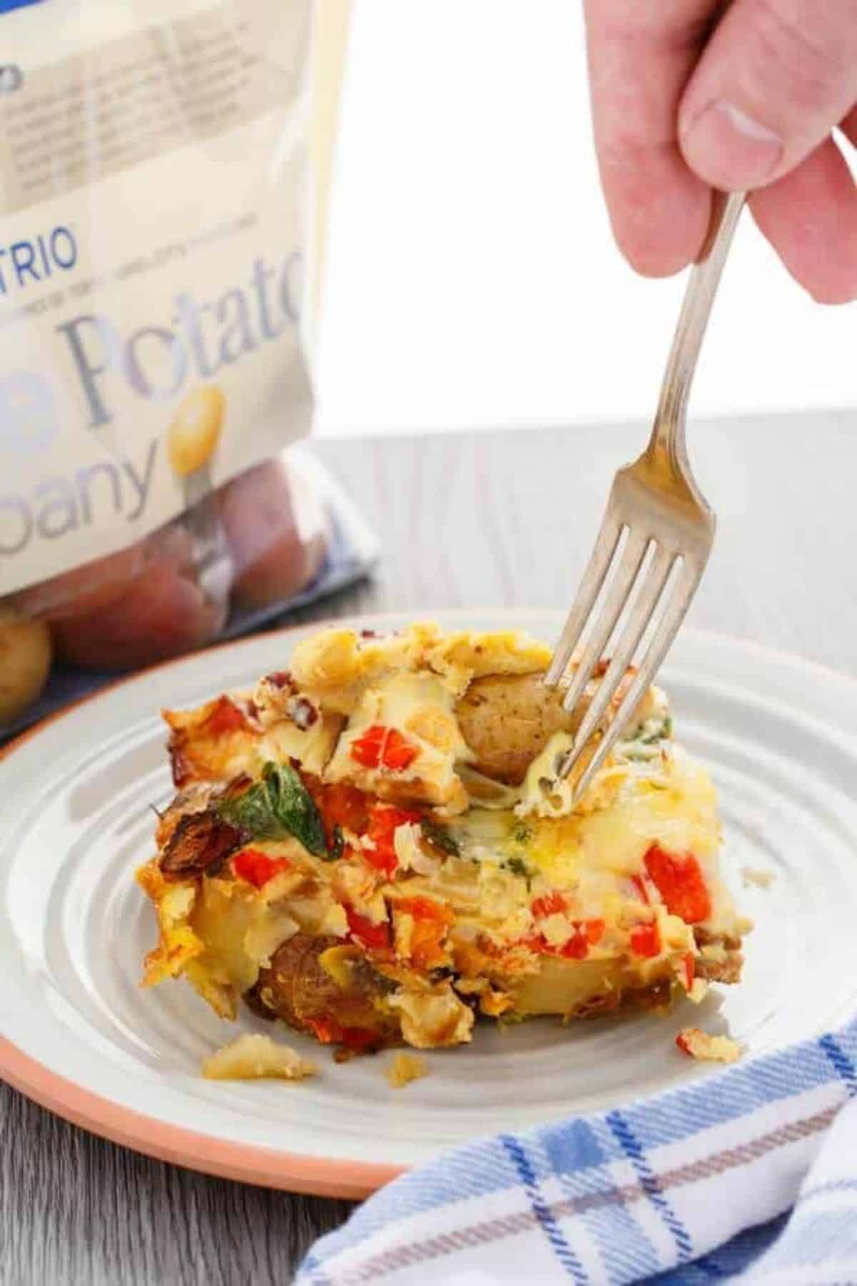 A piece of  Overnight Breakfast Casserolepm a plate picked by a fork.