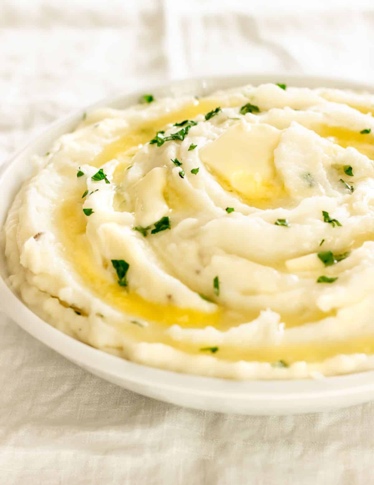 Creamy Sour Cream Mashed Potatoes in a white bowl.