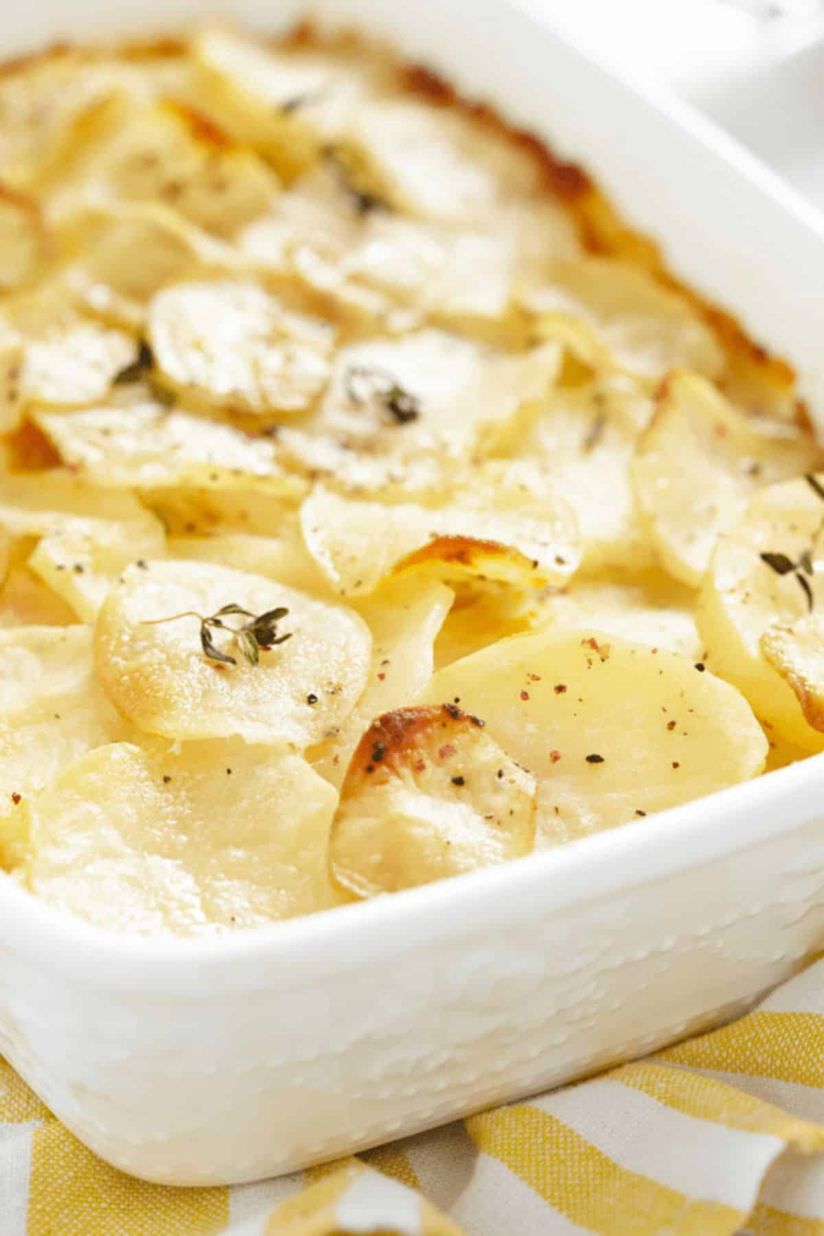 Delicious Scalloped Potatoes in a white casserole.