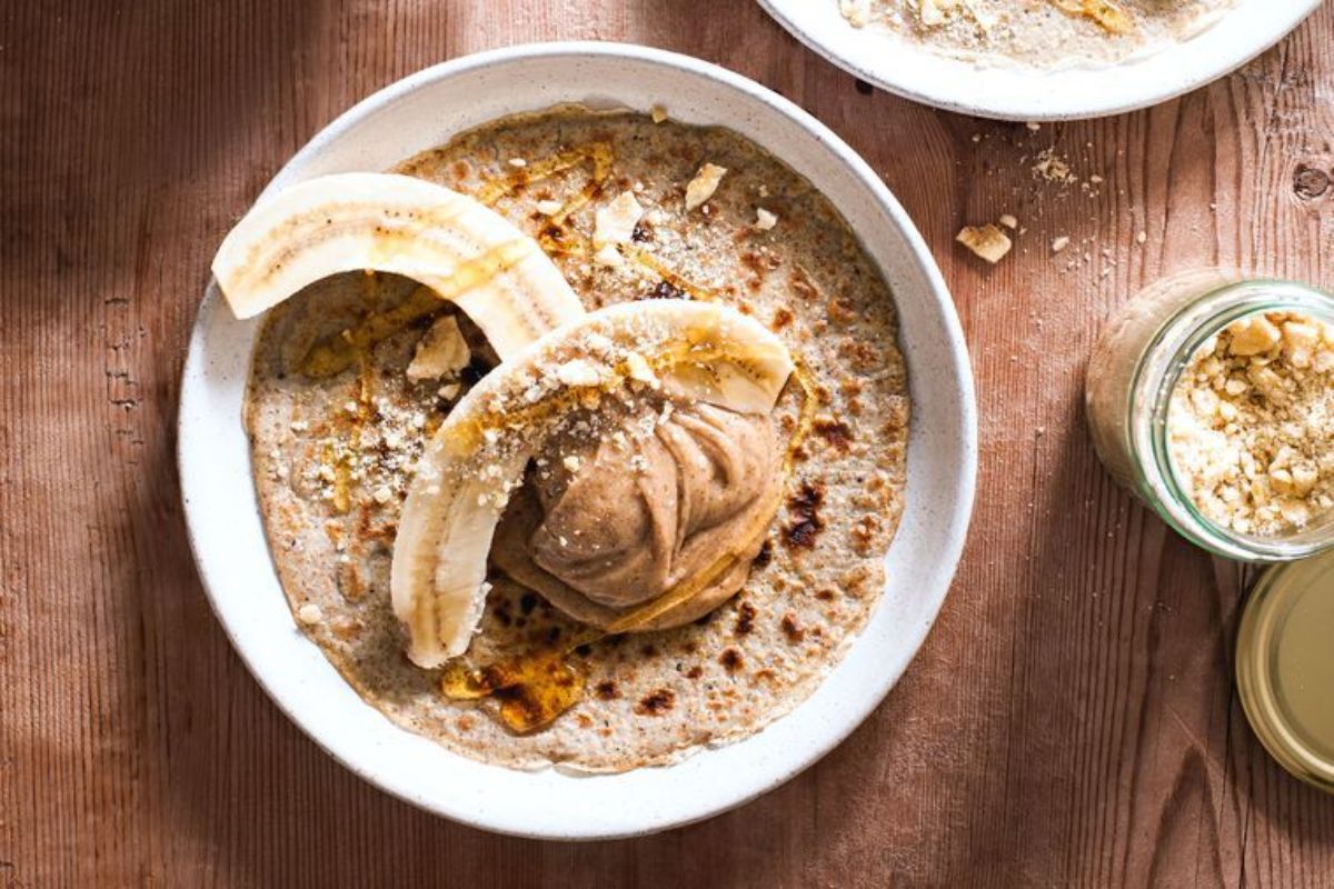 Scrumptious Cardamom Rye Crepes with Banana and Salted Caramel in a white bowl.