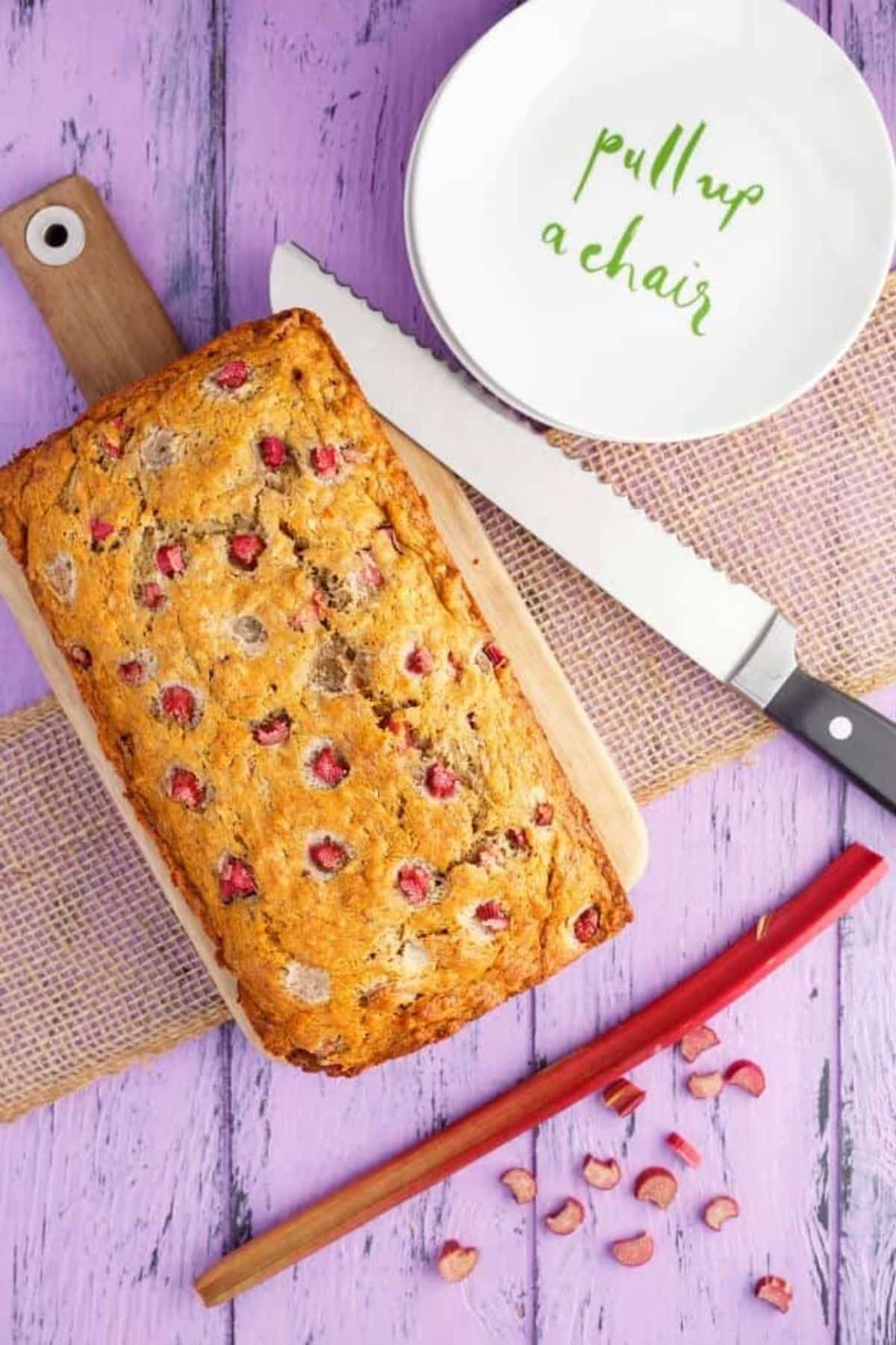 A loaf of Honey-Rhubarb Banana Bread on a wooden cutting board.